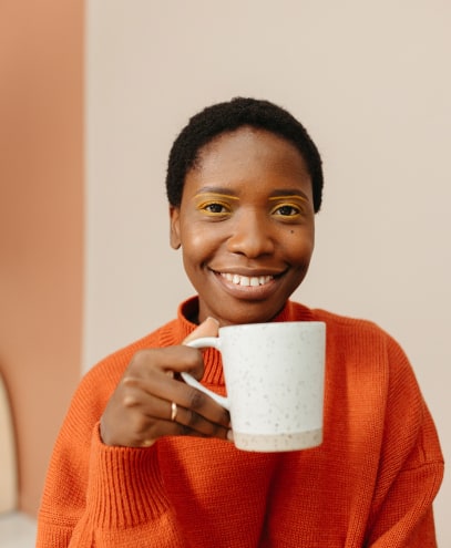 Happy brown woman drinnking coffee